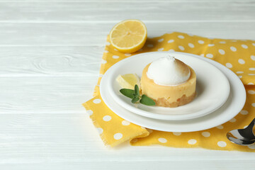 Concept of tasty breakfast with lemon cupcake on white wooden table