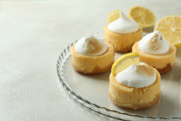 Tasty lemon cupcakes on tray on white textured table