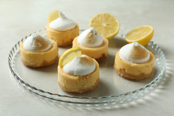 Tasty lemon cupcakes on tray on white textured table