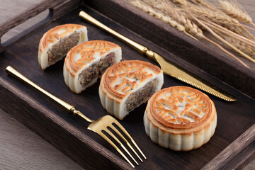 The moon cakes in the wooden box from missing to round and a pair of forks and knives