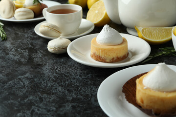 Concept of tasty breakfast with lemon cupcakes and macaroons