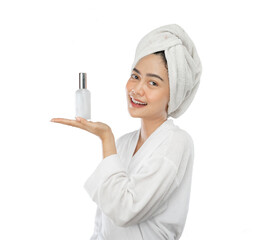 beautiful woman in towel with gesture presenting something while holding perfume bottle on gray...