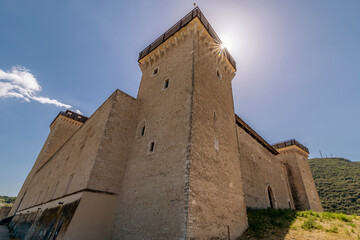 The sun filters over the top of the Rocca Albornoziana fortress in Spoleto, Italy