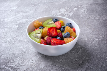 Bowl of healthy salad with fresh fruits and berries