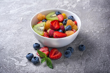 Bowl of healthy salad with fresh fruits and berries
