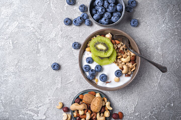 Bowl of healthy breakfast with granola, yogurt, fresh fruits, berries and nuts
