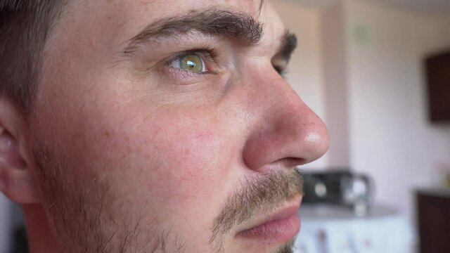 Tense Male Facial Expression Close-up. Running Gaze of Male Eyes. Side View of Perplexed Man with Serious Facial Expression