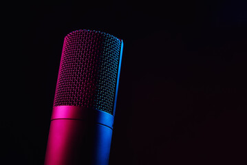 Studio microphone on dark background with copy space. Black professional condencer microphone with...