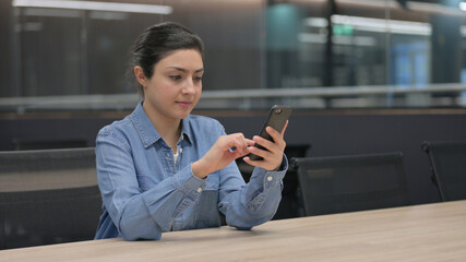 Fototapeta na wymiar Indian Woman using Smartphone at Work