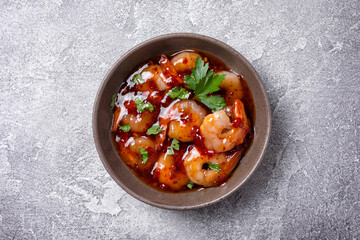Tasty bright seafood. Bowl of shrimps in spicy asian red sauce