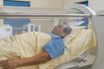 Man relaxed inside a machine for hyperbaric treatment