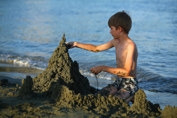 Childen building sand castles out of black volcanic cyprus sand