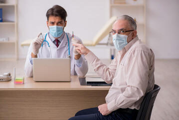 Old male patient visiting young male doctor in vaccination conce