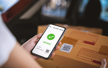 Startup small business, hand using smartphone with scan QR code on cardboard box delivery for...