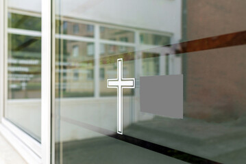 Closeup of a white cross on a window. Funeral house summer day after covid-19 pandemic.Copy space.
