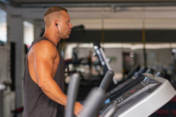 Fototapeta na wymiar Young man in sportswear running on treadmill at gym.Handsome sport gym man running on the treadmill.Indoors shot.
