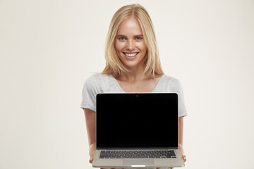 Naklejka premium Young smiling blonde european girl present laptop