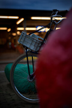 ENSCHEDE, NETHERLANDS - Jul 09, 2021: Bike with a basket parked at the main train station at dusk in Enschede, Netherlands