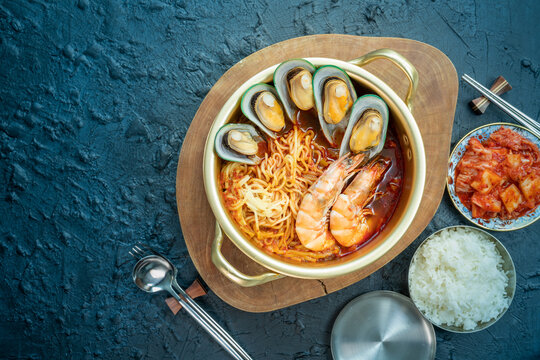 jamppong, Spicy mixed-up seafood noodle soup, Korean noodle soup with red spicy seafood, rice and  kimchi.