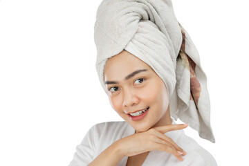 beautiful girl with bath towel on head smiling with hands under chin on gray background