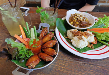 Fried sticky rice served with northern thai curry and chicken wings