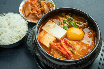 kimchi stew or kimchi soup. Korea’s national dish spicy soup with vegetable, meat, eggs, tofu served in a hot pot. Kimchi Jjigae