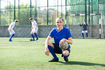 Portrait of teen boy soccer player in blue t-shirt on the field