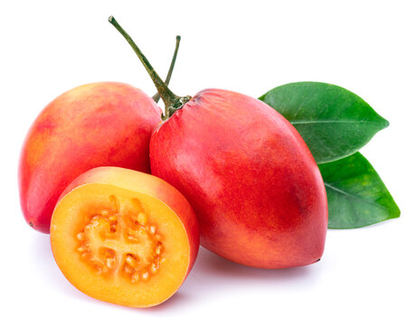 Ripe tamarillo fruits with slices and tamarillo leaves isolated on a white background.