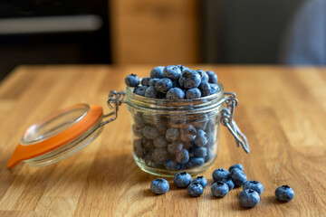 Glass jar with blueberries on wooden table 