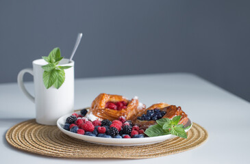 cup of tea with mint and dessert with berries