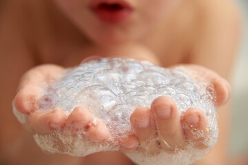 A child is playing with soap suds in the bathroom.