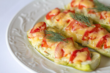 zucchini stuffed with fish with rice and cheese, garnished with tomatoes