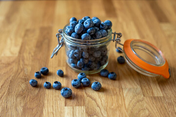 Blueberries in glass jar on a wooden background