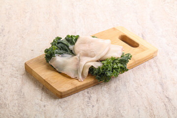 Raw squid over wooden board