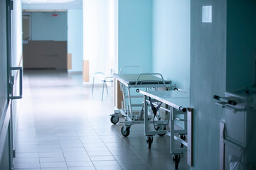 Empty hospital corridor with medical gurneys.