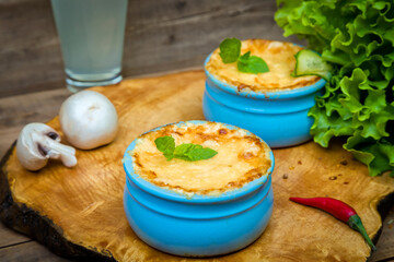 Pots with mushroom julienne on a wooden board.