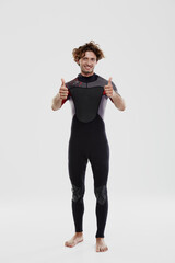 Young european surfer showing thumbs up gesture
