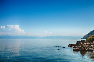 A beautiful natural landscape with a lake, shore and rocks in summer, warm sunny weather.