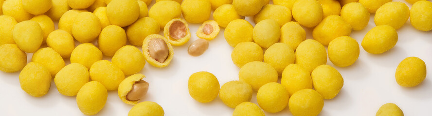 Yellow salty glazed peanuts with cheese flavor on white surface
