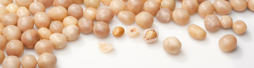 Sweet roasted peanuts in sugar glaze on white surface