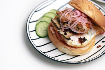 Homemade chicken burger with cheese and french fries on a plate isolated on white background