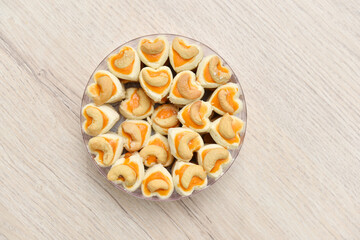 Singapore cookies in plastic box on wooden table.