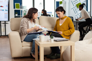 Angry manager woman screaming at employee disagreeing about bad business contract sitting on couch at office desk. Women colleagues having big conflict, dispute about mistakes from project documents