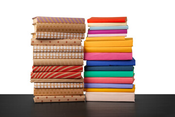 Stack of books on wooden table against white background