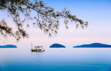 Beautiful sea scape with lonely traditional khmer boat, distant islands in morning mist, blue sky,...