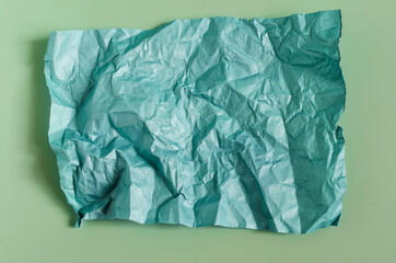 Crumpled green paper on a green background. The texture of crumpled paper for the background.