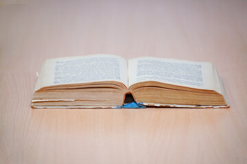 An open book on a wooden table. Selective focus