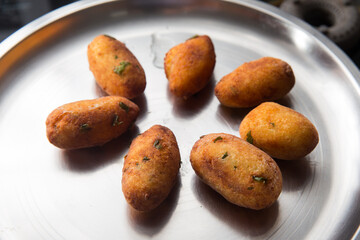 Fried crispy koftas served in a plate, an Indian vegetarian food Malai Kofta being prepared by deep frying corn balls stuffed with meshed potatoes and paneer and topped up with rich creamy gravy or cu