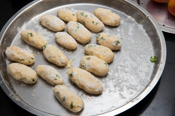 Raw Koftas of  an Indian vegetarian food Malai Kofta being prepared by deep frying corn balls stuffed with meshed potatoes and paneer and topped up with rich creamy gravy or curry