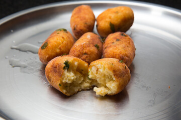 Fried crispy koftas served in a plate, an Indian vegetarian food Malai Kofta being prepared by deep frying corn balls stuffed with meshed potatoes and paneer and topped up with rich creamy gravy or cu